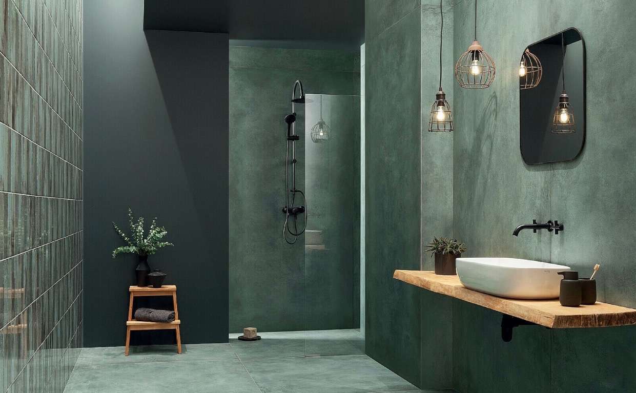Nowoczesna łazienka w odcieniach zieleni z kabiną prysznicową typu walk-in, umywalką nablatową na drewnianym blacie i wiszącymi lampami w stylu industrialnym.