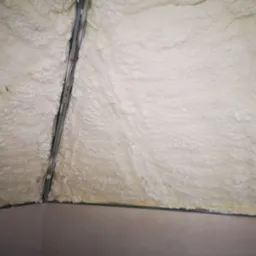 Poddasze po ociepleniu pianką PUR, widoczne metalowe profile konstrukcyjne i nierównomierna struktura piany.