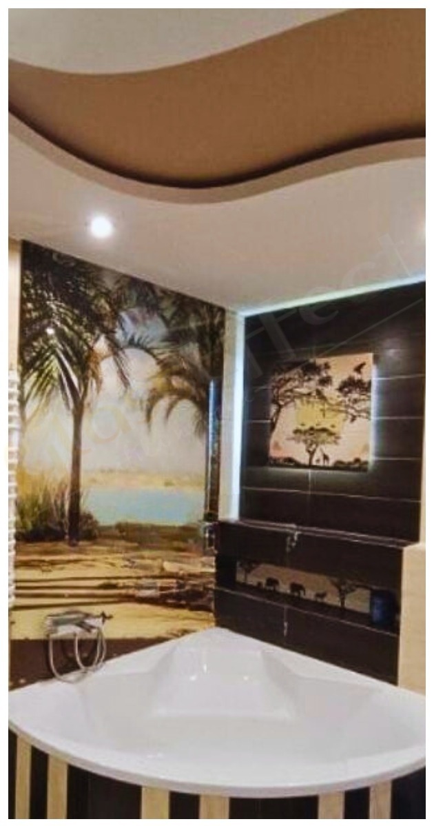 Narożna wanna w łazience z motywem afrykańskim na ścianach, w tym fototapeta z palmami i obraz z sylwetkami zwierząt na tle zachodzącego słońca.