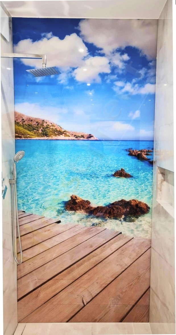 Szklana ściana prysznicowa z fotorealistycznym motywem plaży, przedstawiająca drewniany pomost przechodzący w turkusową wodę i błękitne niebo z chmurami.