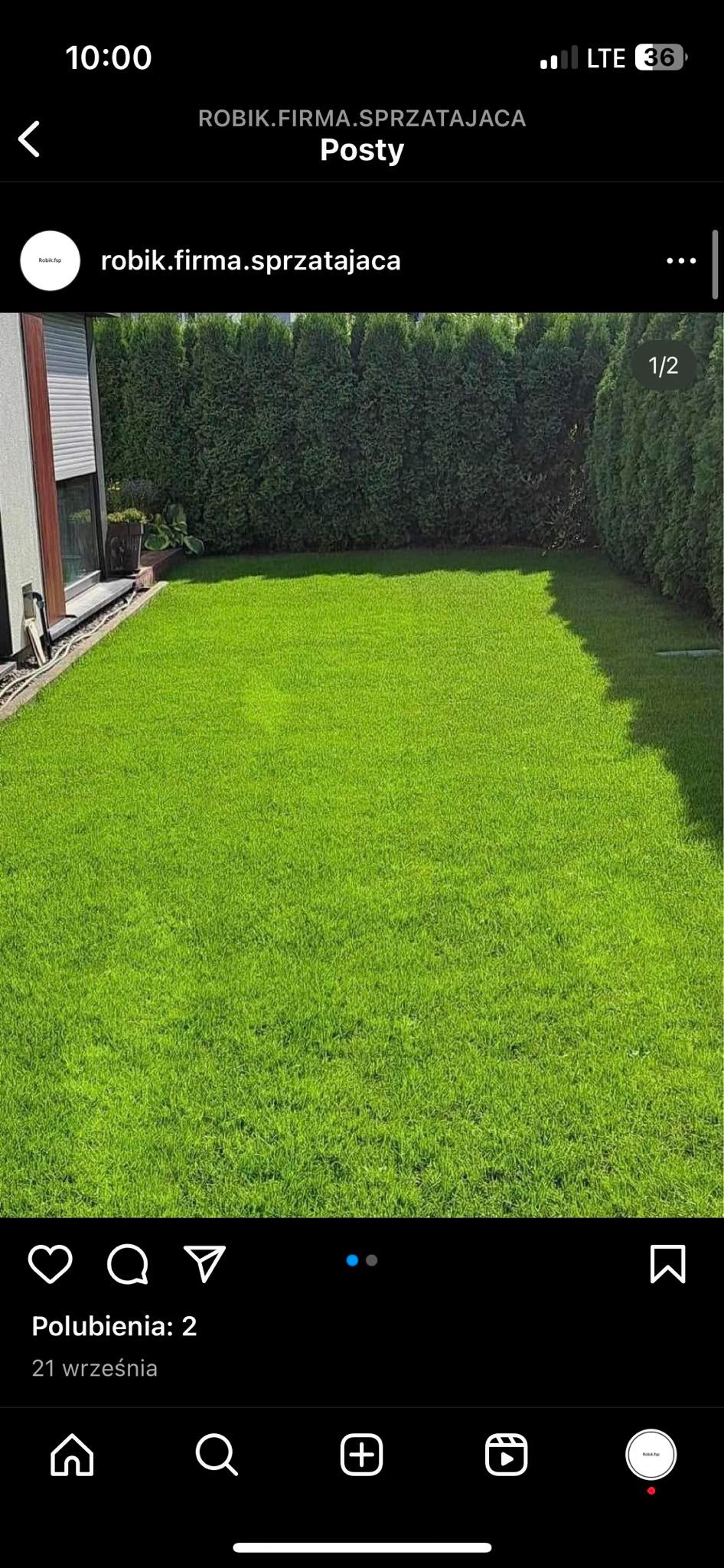 Starannie przystrzyżony trawnik przed budynkiem z tujami w tle, widok z góry.