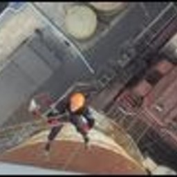 Prace wysokościowe - profesjonalne usługi alpinistyczne - Pracownik w kasku i uprzęży asekuracyjnej, stojący na dachu budynku podczas mycia elewacji, widok z góry.