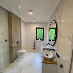 Usługi Remontowo Budowlane Kamil Krawczyk - Nowoczesna łazienka z marmurowymi płytkami, podwójną umywalką nablatową i kabiną prysznicową typu walk-in.