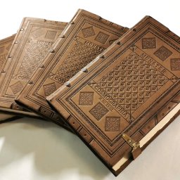 Książki Cosmographia w oprawach skórzanych historyzujących, stylizowanych na średniowieczne, zapinane na rzemienie z mosiężnymi haczykami, ze ślepymi tłoczeniami wykonanymi ręcznie. Oprawy skórzane książek, kompletowanie księgozbiorów do bibliotek domowych