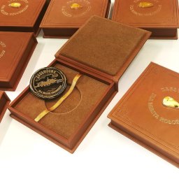 Skórzane pudełka z bursztynami w srebrze, na medale Zasłużony dla Miasta Kołobrzeg, etui na medal z prawdziwej skóry, środek wykończony tkaniną ozdobną, okładki pudełek zdobione naturalnymi bursztynami mlecznymi. Pudełka na medale realizacja Pimax Koszalin