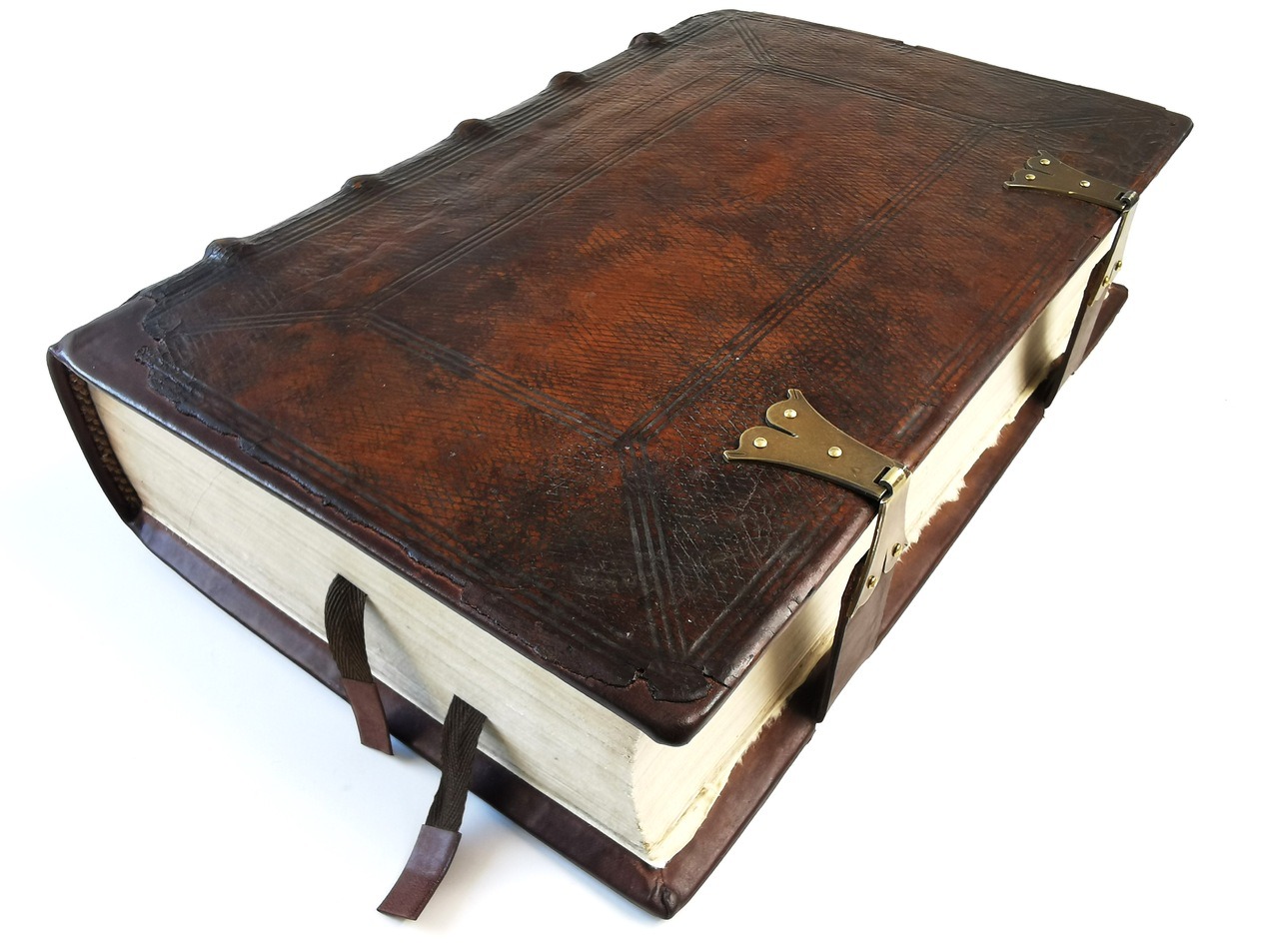 Duży, gruby mszał w skórzanej oprawie, z mosiężnymi zapięciami i zakładkami, leżący na białym tle.