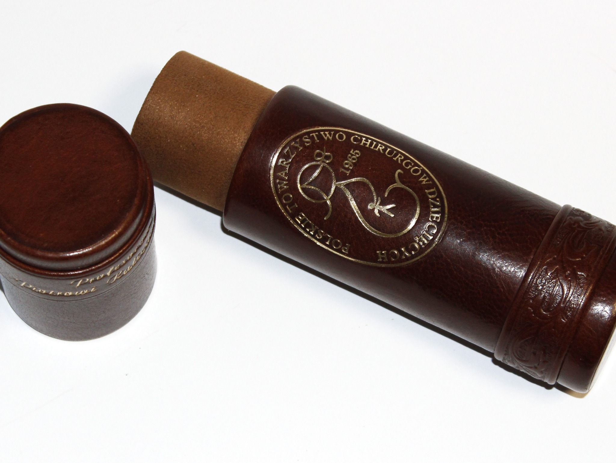 Skórzana tuba na dyplom A4 z tłoczonym złotym logo Polskiego Towarzystwa Chirurgów Dziecięcych, wykonana ręcznie w Pracowni PIMAX w Koszalinie.