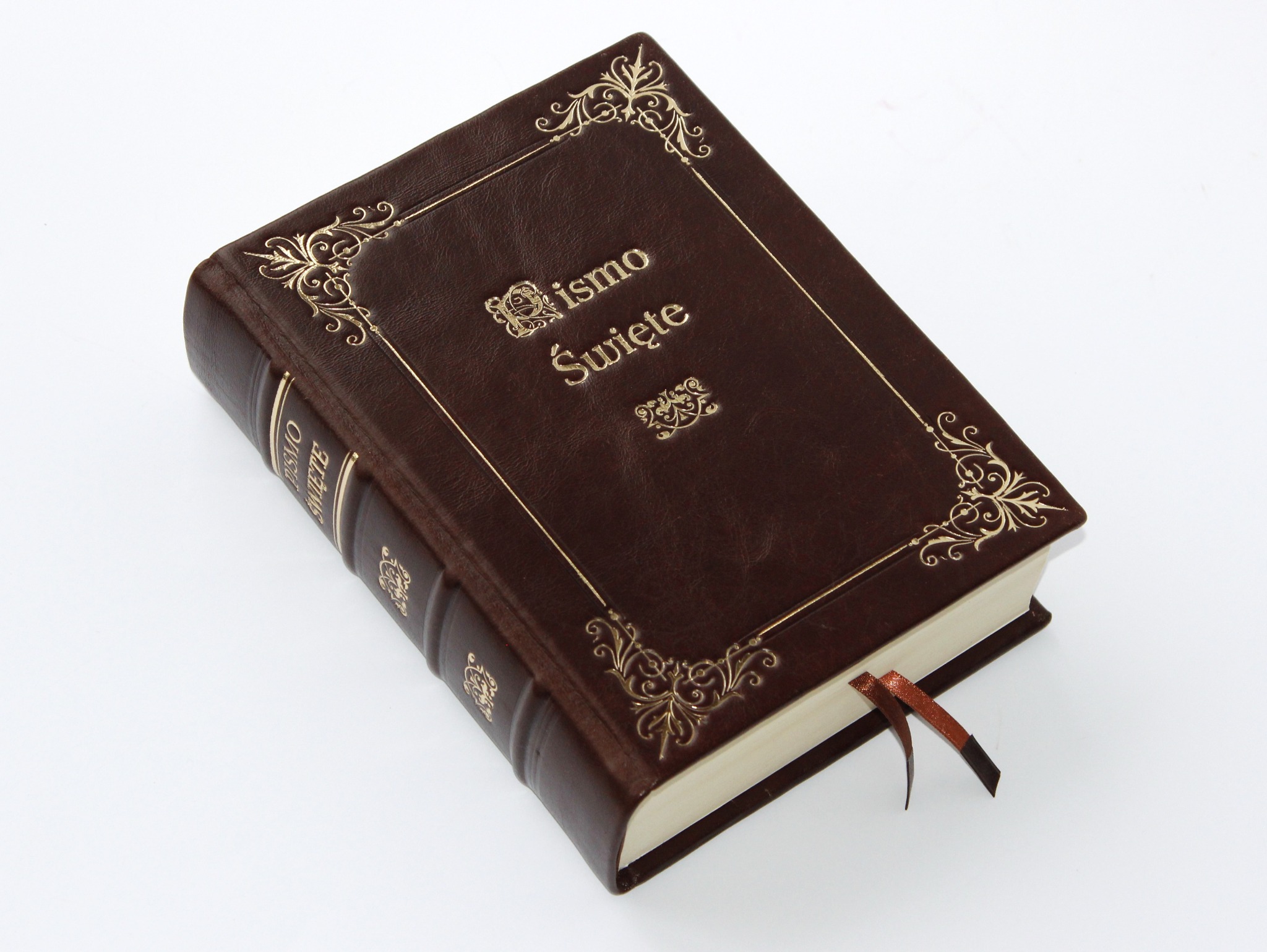 Elegancka, brązowa Biblia w skórzanej oprawie z ozdobnymi, złoconymi detalami i zakładką, leżąca na białym tle. Widoczny bok z tłoczonym napisem.