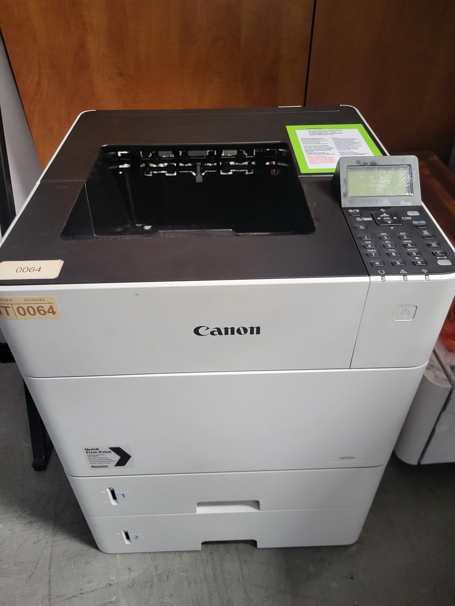 Używana kserokopiarka Canon z panelem sterowania i etykietą inwentaryzacyjną, ustawiona na podłodze.