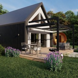Woody House - Wizualizacja domu modułowego z czarną elewacją, drewnianym tarasem z pergolą, okrągłą sauną beczką w ogrodzie i bawiącym się dzieckiem na trawniku.