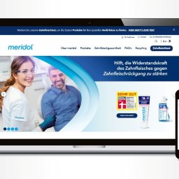 Arteon - Laptop i smartfon wyświetlają stronę internetową Meridol z uśmiechniętymi dentystami i produktami do higieny jamy ustnej. Strona w języku niemieckim.