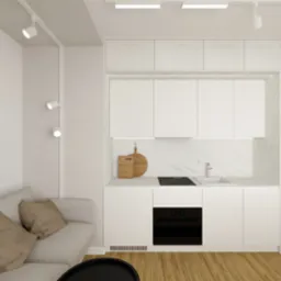 Wnętrze mieszkania z aneksem kuchennym w minimalistycznym stylu, z białymi szafkami, marmurowym blatem, drewnianą podłogą i abstrakcyjnym obrazem na ścianie. Na blacie kuchennym deski do krojenia...