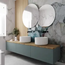 Nowoczesna łazienka z dwoma okrągłymi lustrami, umywalkami nablatowymi i szafką w kolorze morskim, akcentowana drewnianymi panelami i tapetą w kwiatowe wzory.