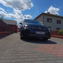 AUTO-DETAILING KAMIL KNOP - Czarny Volkswagen Golf R na brukowanym podjeździe z polską tablicą rejestracyjną PY 99173, na tle domu i błękitnego nieba z chmurami.