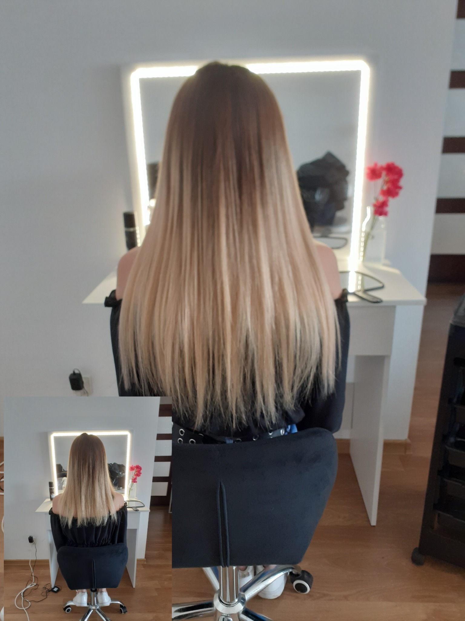 Długie włosy ombre, od brązu u nasady do jasnego blondu na końcach, widok z tyłu, oświetlone lustro w tle, klientka siedzi na czarnym krześle.