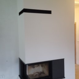 M INSTAL s.c. Monika Woźniak, Sebastian Woźniak - Kominek narożny z podnoszoną szybą do góry. Zabudowa kamienna wykonana z czarnego granitu.