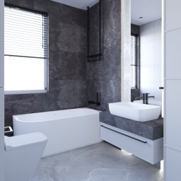 ZEBRA studio - Nowoczesna łazienka z wanną, umywalką nablatową i szarą okładziną imitującą kamień, uzupełniona o czarne akcenty armatury i minimalistyczne oświetlenie.