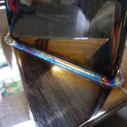 MARZOS Agnieszka Gołąb - Spoina TIG na stali nierdzewnej, widoczne tęczowe przebarwienia termiczne, wysoki połysk metalu.