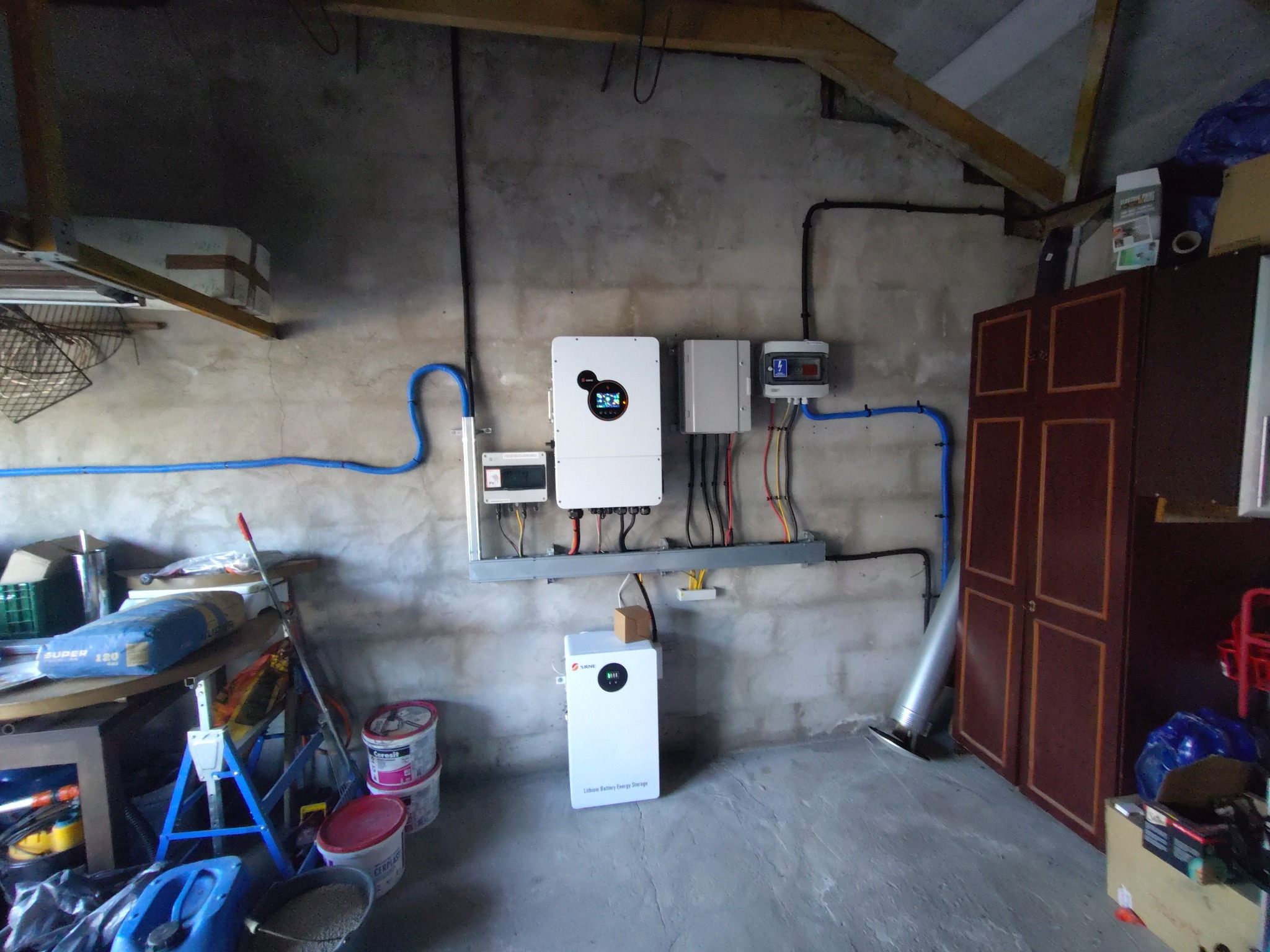 Zainstalowany system fotowoltaiczny z magazynem energii w garażu w Środzie Wielkopolskiej. Widoczne inwertery, okablowanie i akumulator.