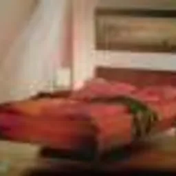 Sypialnia z łóżkiem z ciemnego drewna, czerwona pościel, szafki nocne po bokach, obraz na ścianie, ciepłe oświetlenie.