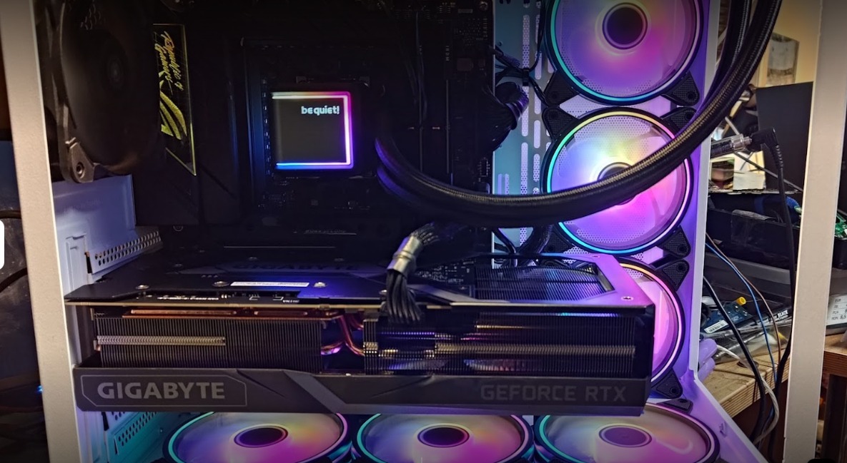 Wnętrze komputera stacjonarnego z kartą graficzną Gigabyte GeForce RTX, chłodzeniem wodnym i podświetlanymi wentylatorami RGB.