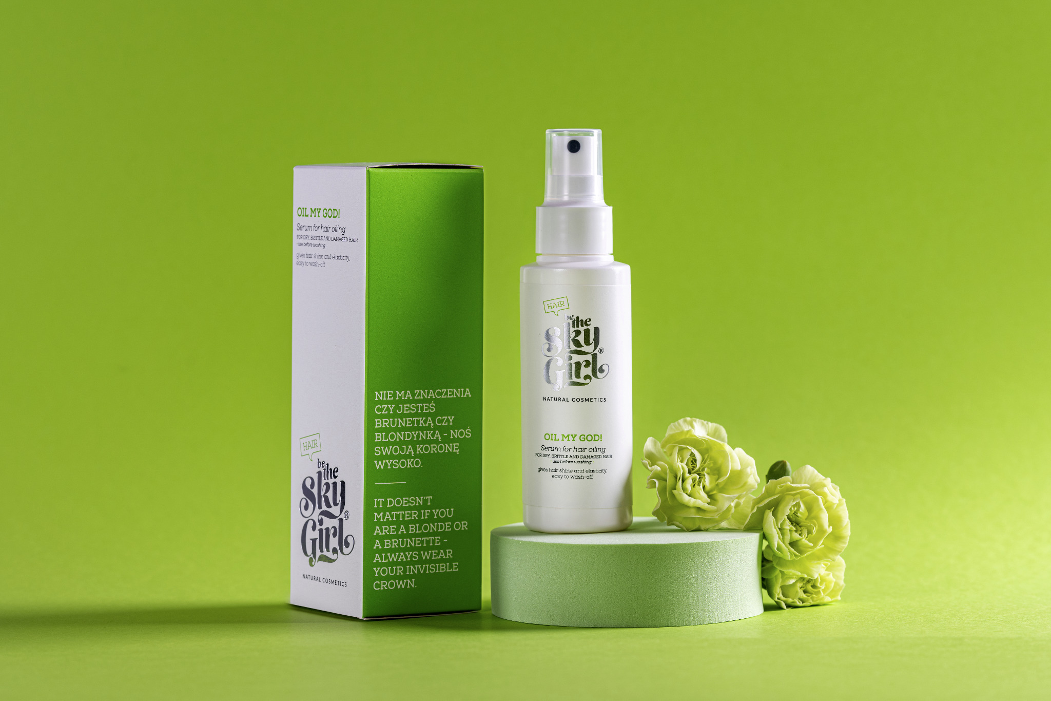 Zdjęcie produktowe: biała butelka serum do włosów i pudełko kosmetyków Be The Sky Girl na zielonym tle, ozdobione zielonymi goździkami, umieszczone na zielonej platformie.