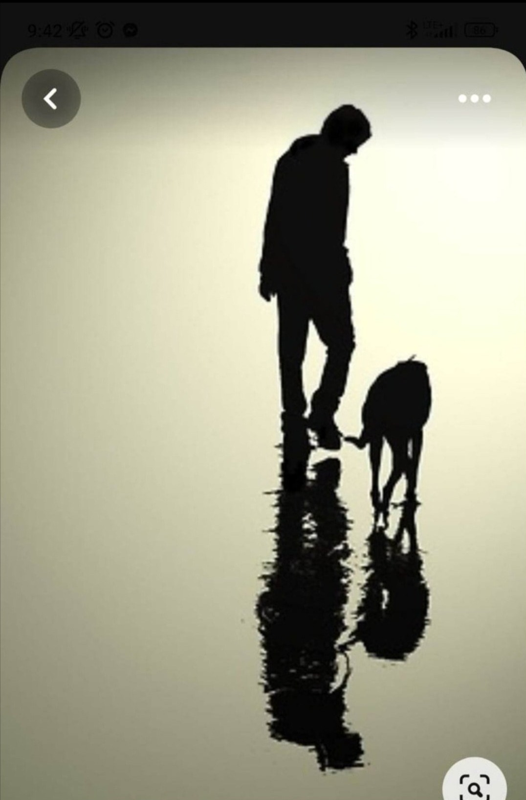 Sylwetka mężczyzny i psa na mokrym piasku w Mielcu, odbicie w wodzie, stonowana kolorystyka.