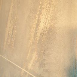 Piotr Wicherek - Tekstura ściany z efektem malowania pędzlem w odcieniach beżu i błękitu, z widoczną linią podziału kolorów.