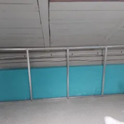 Metalowy szkielet pod zabudowę, wypełniony turkusową wełną mineralną, widok na drewniany sufit