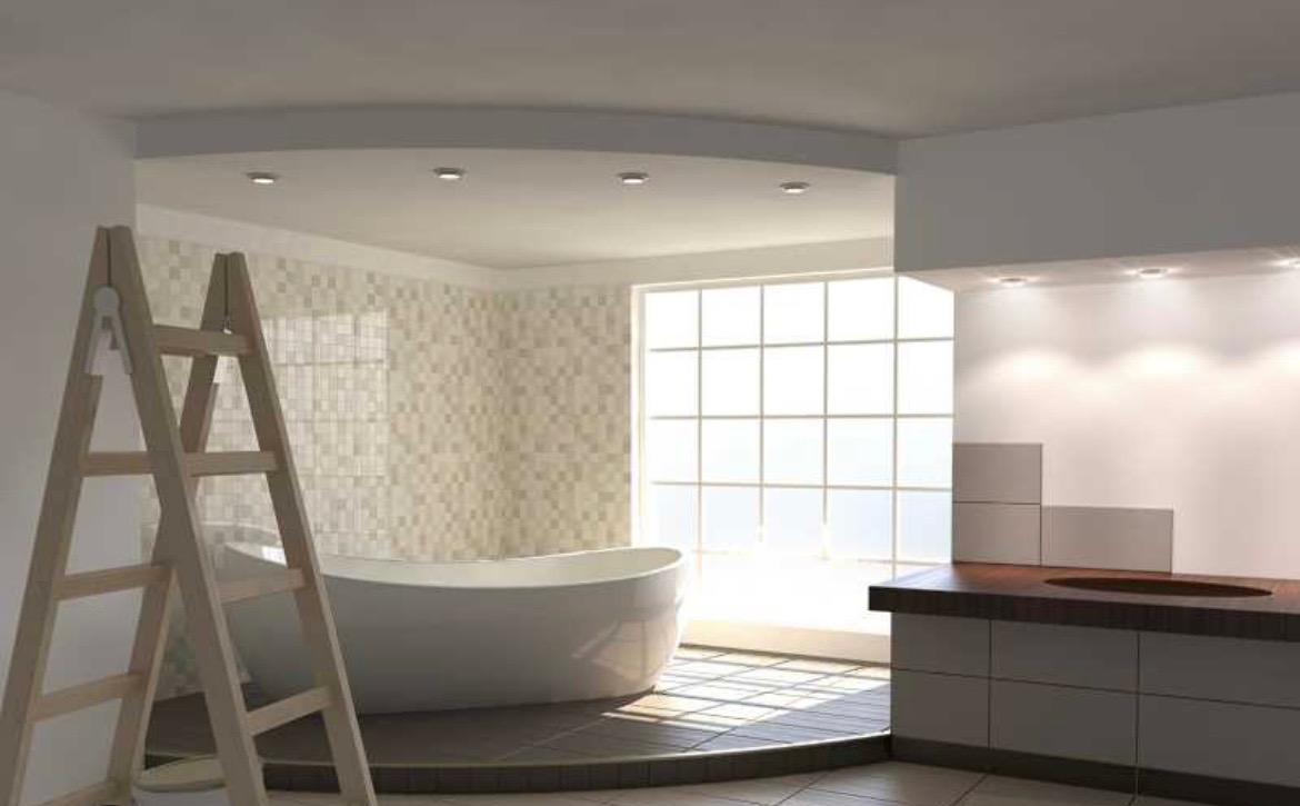Wnętrze łazienki w trakcie prac wykończeniowych, widoczna drabina malarska, wanna wolnostojąca i fragment zabudowy umywalkowej, jasne płytki na ścianach i podłodze.