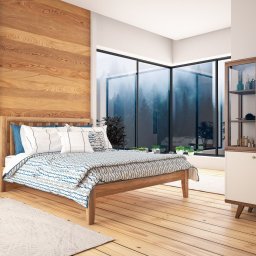 Narysujemy.pl - Jasna sypialnia z drewnianą ścianą, dużym oknem z widokiem na las i drewnianym łóżkiem z niebiesko-białą pościelą, uzupełniona szafką z przeszklonymi drzwiczkami i stolikiem nocnym.