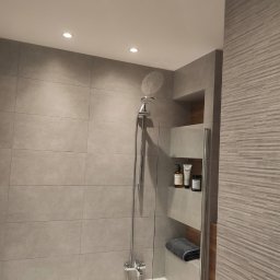 AMGREM SMART BUILDING SOLUTIONS ANATOLII GLADYSH - Nowoczesna łazienka z szarymi płytkami, kabiną prysznicową i wnękami na kosmetyki. Minimalistyczny design, oświetlenie punktowe.