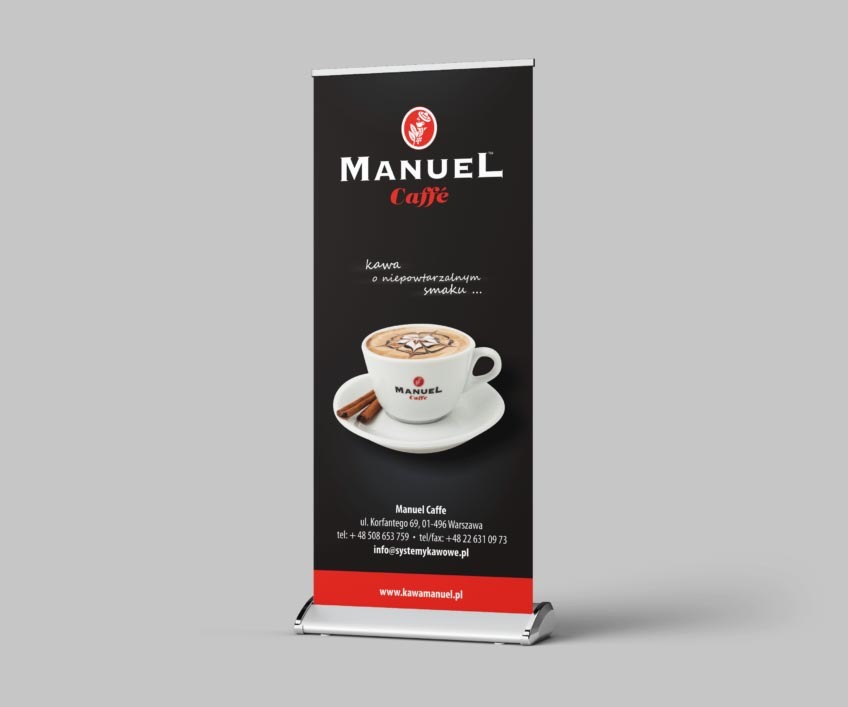 Roll-up reklamowy z grafiką filiżanki kawy z logo Manuel Caffe na czarnym tle, umieszczony na szarym tle.