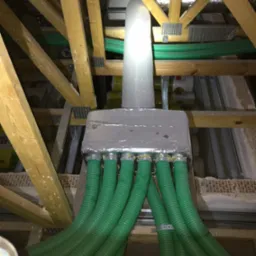 Rozprowadzenie przewodów wentylacyjnych rekuperacji w przestrzeni poddasza, widoczne drewniane elementy konstrukcji dachu i izolacja.