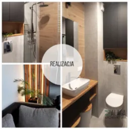 Nowoczesna łazienka z kabiną prysznicową typu walk-in, umywalką nablatową na drewnianym blacie, szarą glazurą i drewnianymi akcentami, uzupełniona zieloną rośliną w półce.