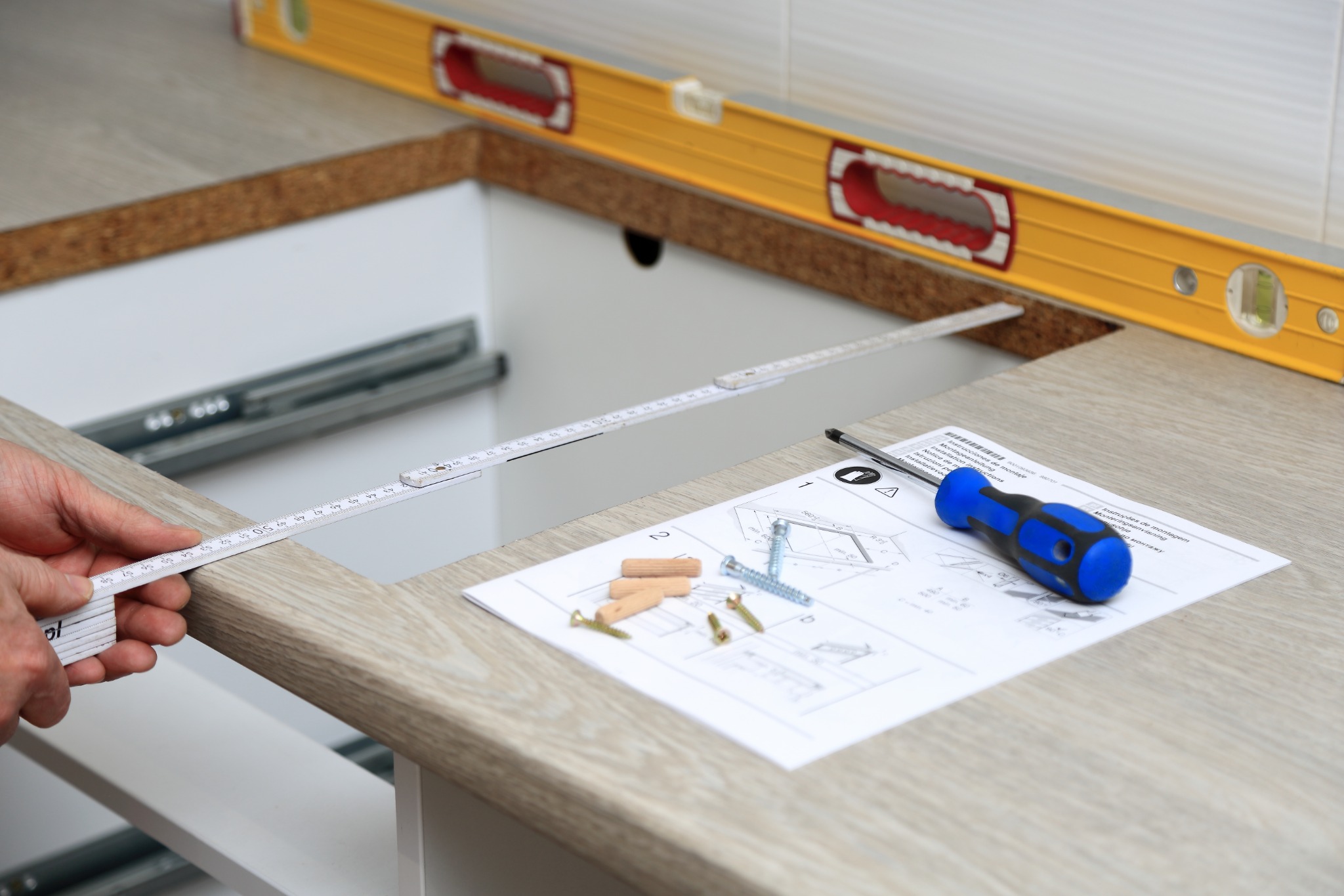 Pomiar blatu pod zabudowę, poziomica, instrukcja montażu, kołki i śruby na blacie