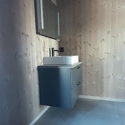 biały montaż łazienki zastosowany na ściany o wykończeniu panelowym oraz wykonana podłoga w klasyczne szare płytki