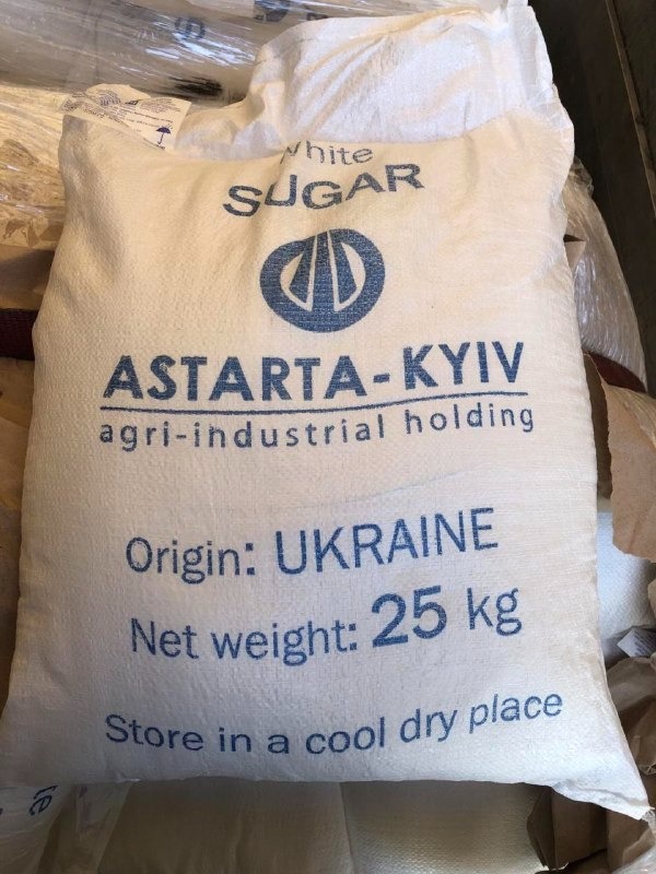 Worek białego cukru marki ASTARTA-KYIV, wyprodukowanego na Ukrainie, o wadze 25 kg, z instrukcją przechowywania w chłodnym, suchym miejscu.