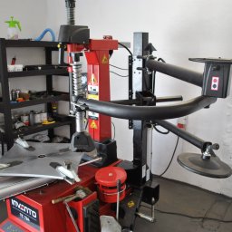 WULKANIZACJA Adam Karaszewski - Wyważarka do opon Invento TC 724 w warsztacie samochodowym, widoczny kompresor i półki z narzędziami w tle.