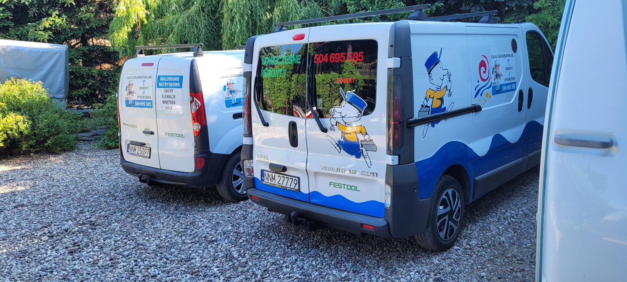 Dwa białe samochody dostawcze z reklamą usług remontowych i numerem telefonu, zaparkowane na żwirowym podjeździe, w tle zieleń.