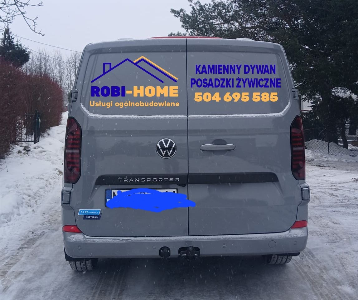 Szary van Transporter z reklamą usług ogólnobudowlanych, kamiennego dywanu i posadzek żywicznych firmy Robi-Home, zaparkowany na ośnieżonej ulicy.