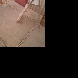 Posmar - Wnętrze w trakcie prac: widoczne przewody elektryczne ułożone na podłodze, drabina aluminiowa, ściany w stanie surowym i częściowo z tapetą.