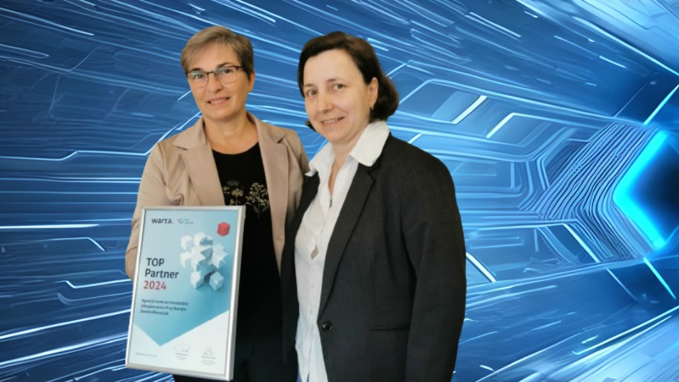 Dwie kobiety prezentują dyplom 'TOP Partner 2024' od TUiR WARTA SA na tle futurystycznego, niebieskiego wzoru.