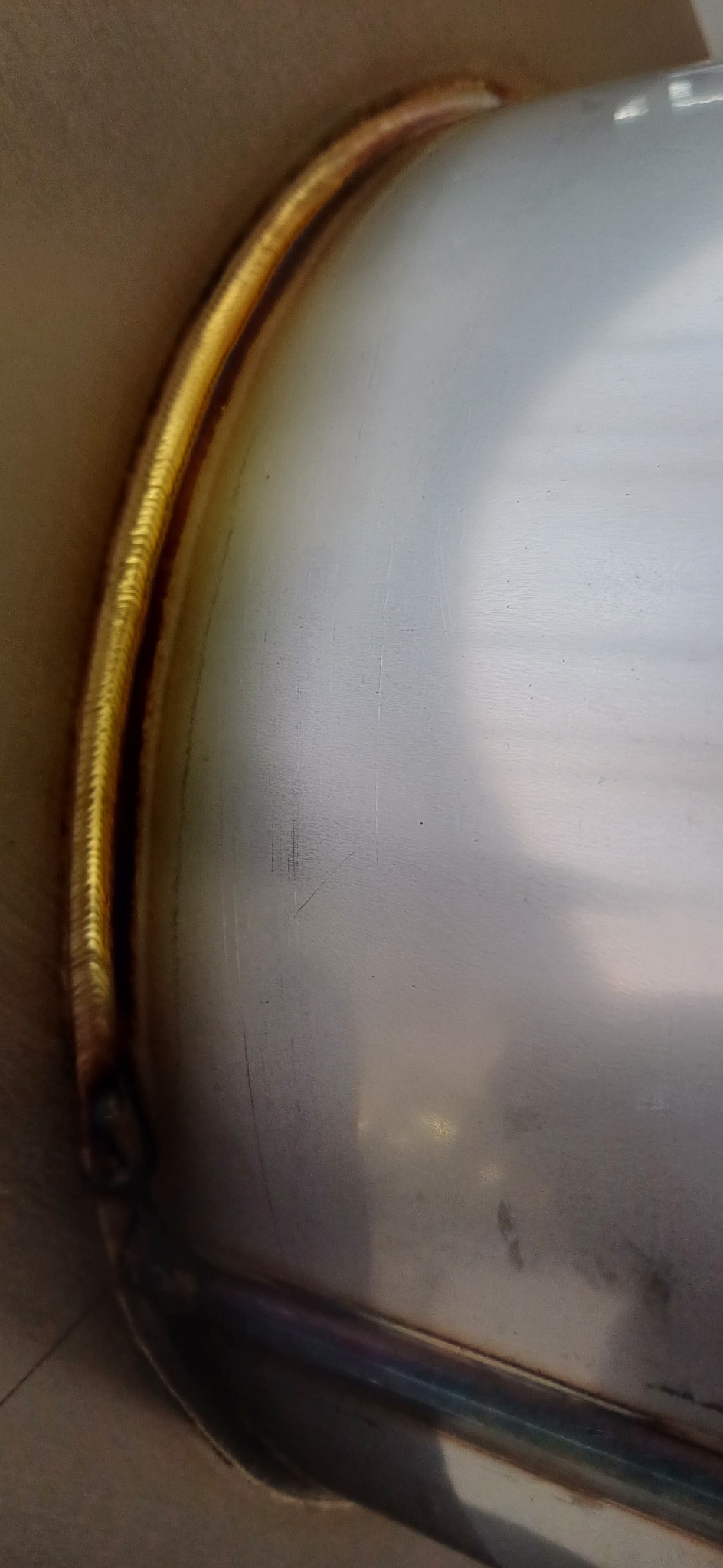 Szczegółowe zbliżenie spoiny na nierdzewnej konstrukcji, widoczna precyzyjna i równa spoina o złotym zabarwieniu, wykonana metodą TIG.