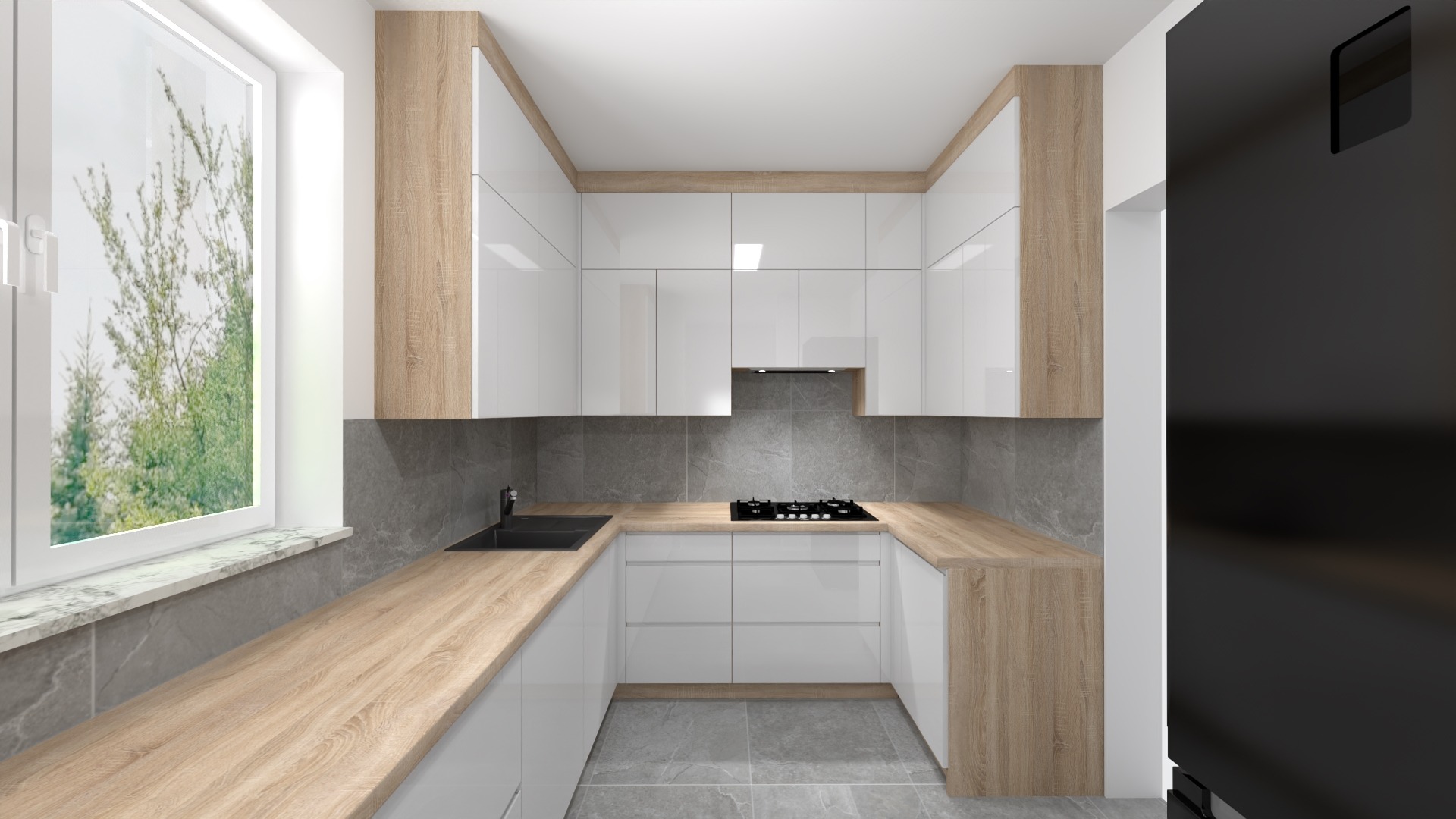 Nowoczesna kuchnia w kształcie litery U z białymi, lakierowanymi frontami, drewnopodobnym blatem i szarą płytką na ścianie, widok na okno z zielenią za szybą i fragment czarnej lodówki.