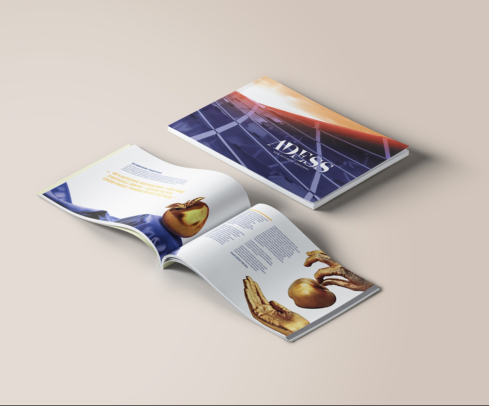 Dwa otwarte katalogi firmy ADESS z grafikami złotych jabłek i rąk na beżowym tle, jeden z okładek przedstawia nowoczesny budynek na tle zachodzącego słońca.