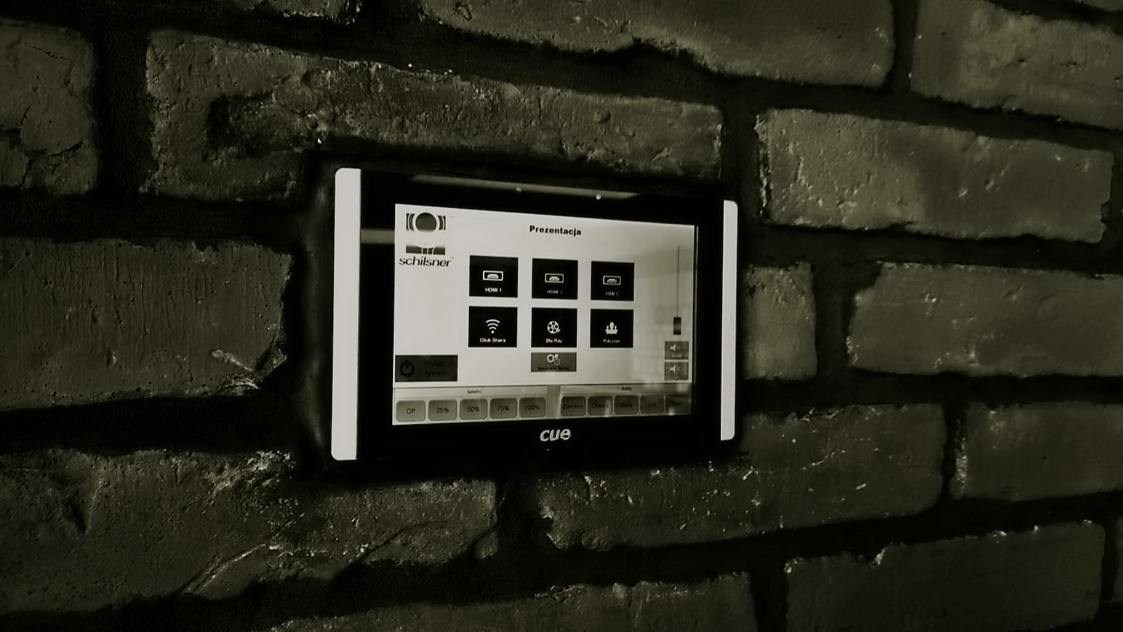 Panel sterowania inteligentnym domem marki CUE zamontowany na ceglanej ścianie we Wrocławiu, wyświetlający menu prezentacji z opcjami HDMI, USB-C i Click Share.