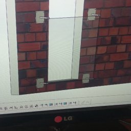 GSM SPOLKA Z OGRANICZONA ODPOWIEDZIALNOSCIA - Widok ekranu monitora z uruchomionym programem do projektowania 3D, prezentującym wizualizację fragmentu ściany z cegły z elementami konstrukcyjnymi mocowanymi na metalowych płytkach. W dolnej...