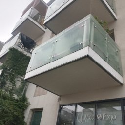 GSM SPOLKA Z OGRANICZONA ODPOWIEDZIALNOSCIA - Nowoczesny budynek z balkonami o szklanych balustradach, częściowo porośnięty zielenią, widziany z dołu pod kątem.