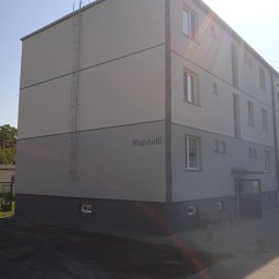 Izol- Complex Tomasz Romanowski - Odnowiony, trzypiętrowy budynek mieszkalny w Aleksandrowie Kujawskim z jasnoszarą elewacją, ciemnoszarym cokołem i numerem 'Wiejska 16', wyposażony w zewnętrzną drabinę przeciwpożarową.